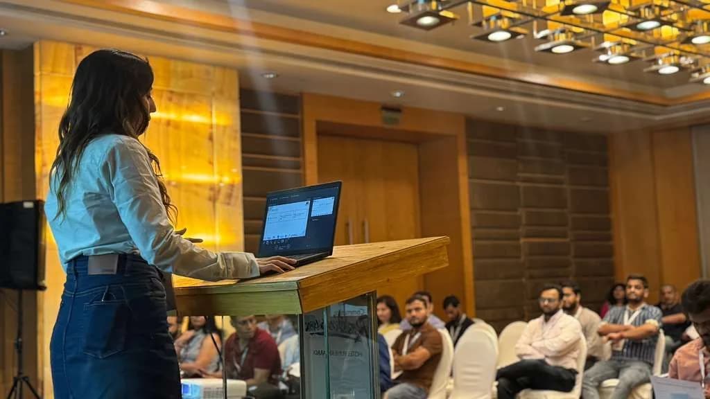 Saumya Smriti presenting from a lectern to an audience.